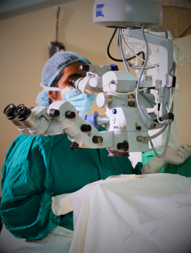A surgeon at an operating microscope in a CMC Vellore theatre