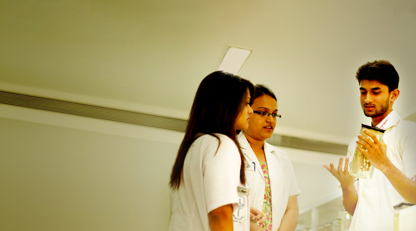 KMC Manipal students examining a specimen in a teaching laboratory
