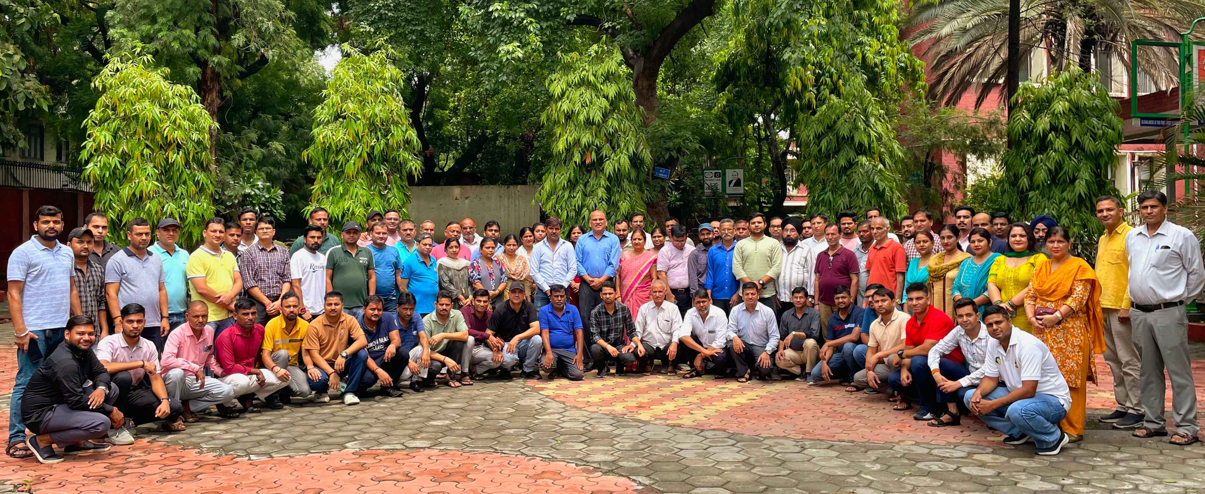 Staff and students in the tree-lined courtyard of the Kirori Mal College campus