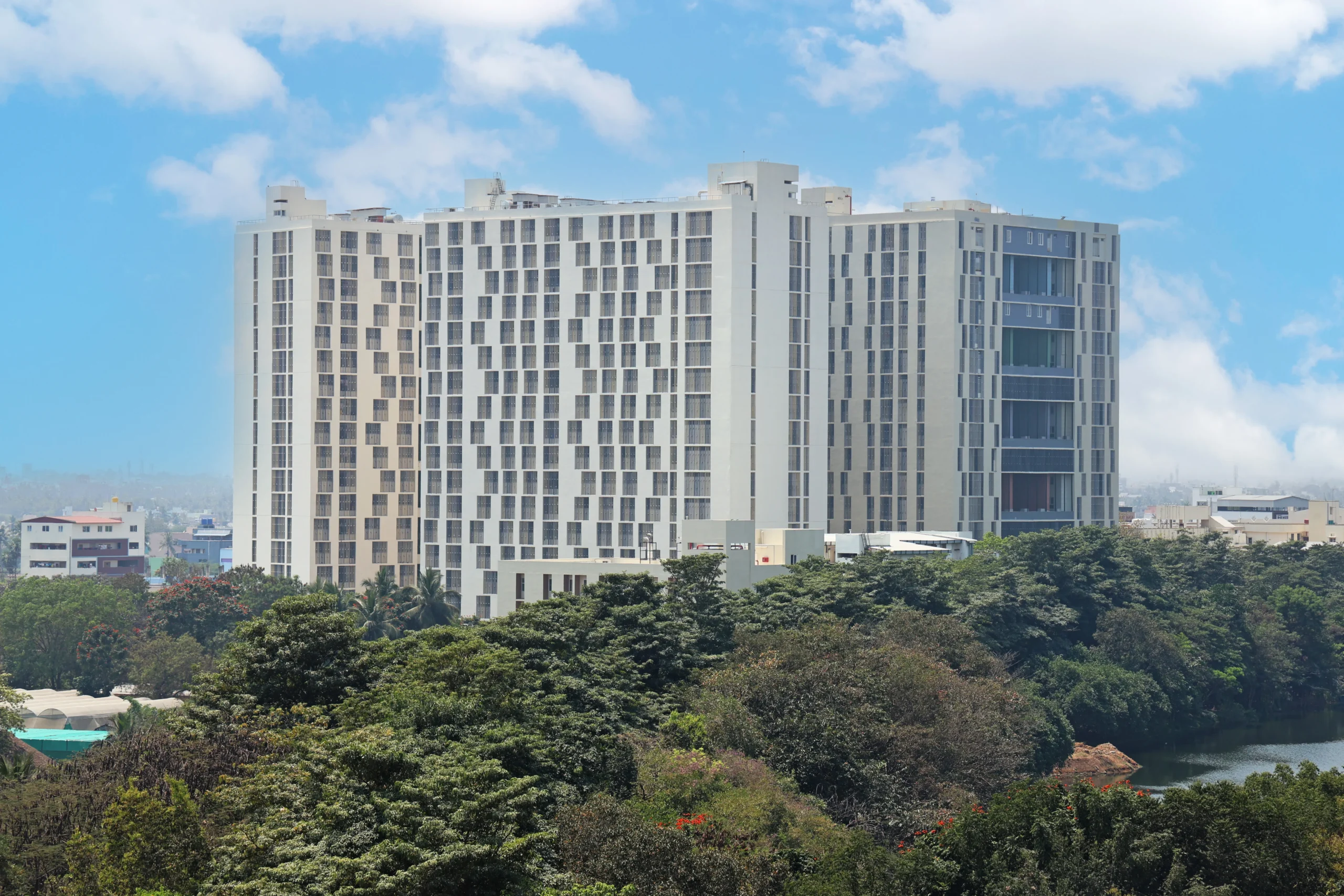 A high-rise residential tower on the VIT Vellore campus beside the lake